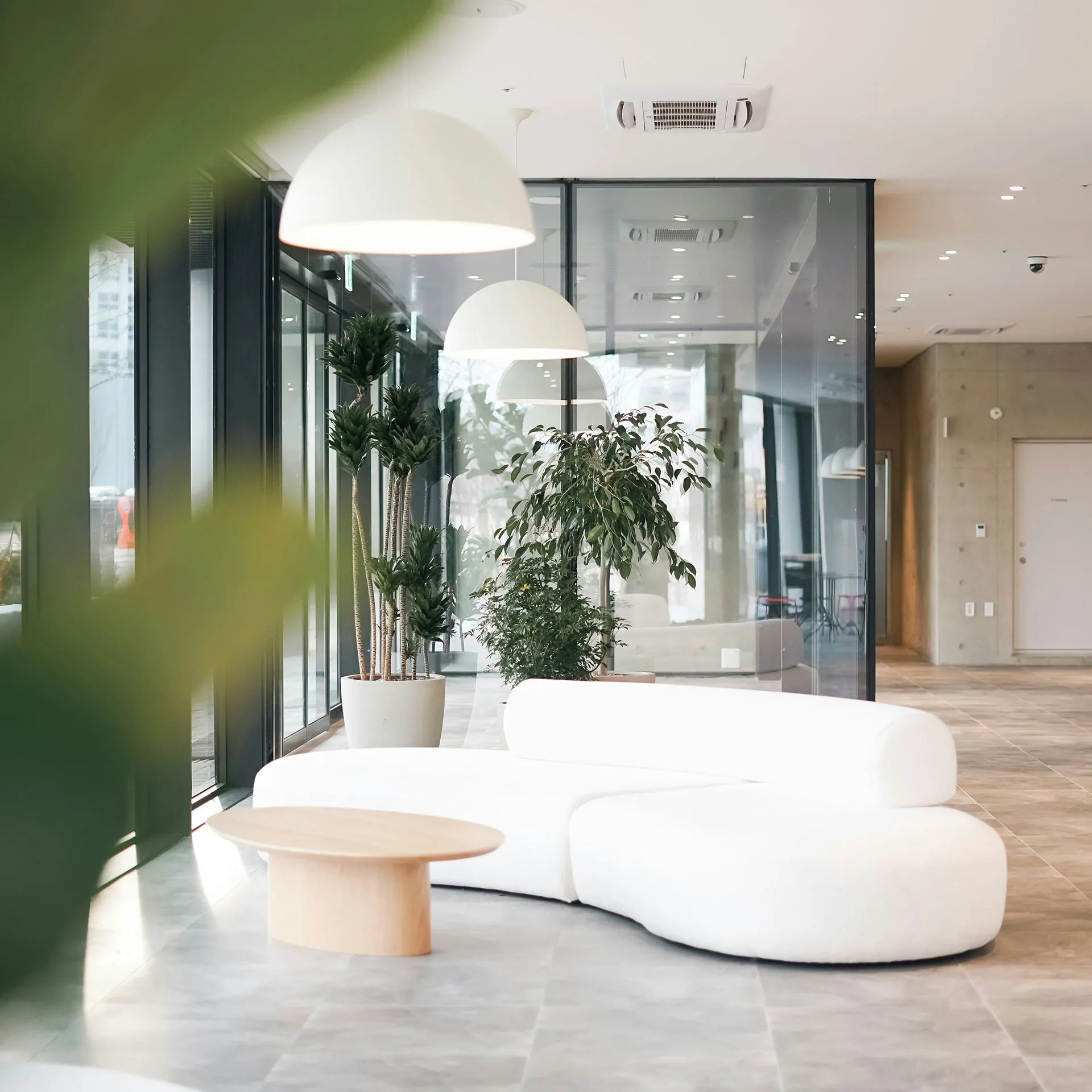 Miljöbild över kontorslandskap med soffgrupp och växter